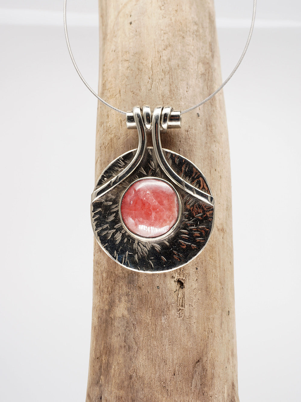 Runder Anhänger mit einem Rhodochrosit und Halskette.